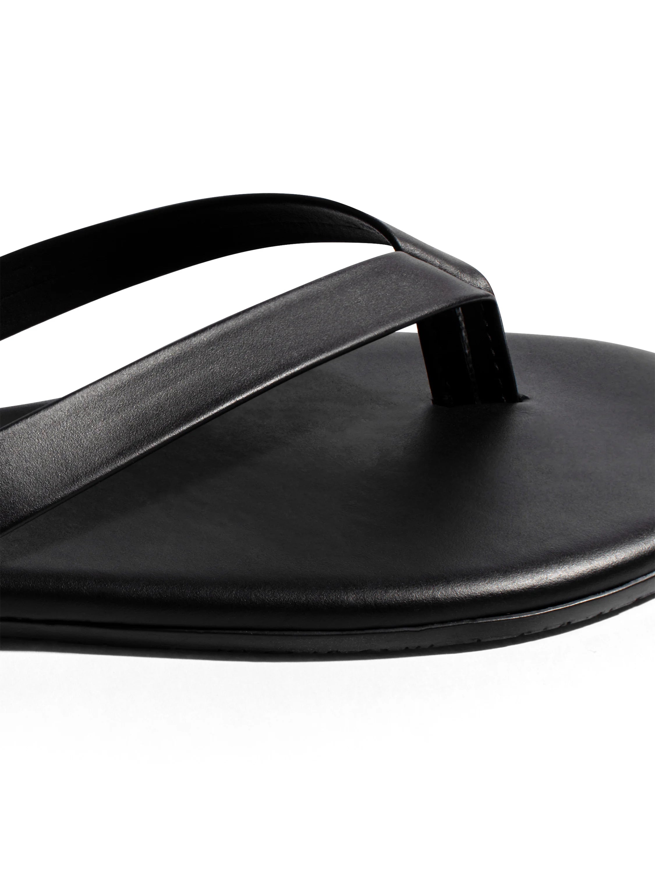 Black leather-look flip-flop with thin, smooth straps and a flat, textured sole.