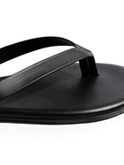 Black leather thong flip-flop; simple, flat sole.