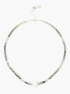 Silver chain necklace with light-blue/grey aquamarine beads and a single off-white pearl.