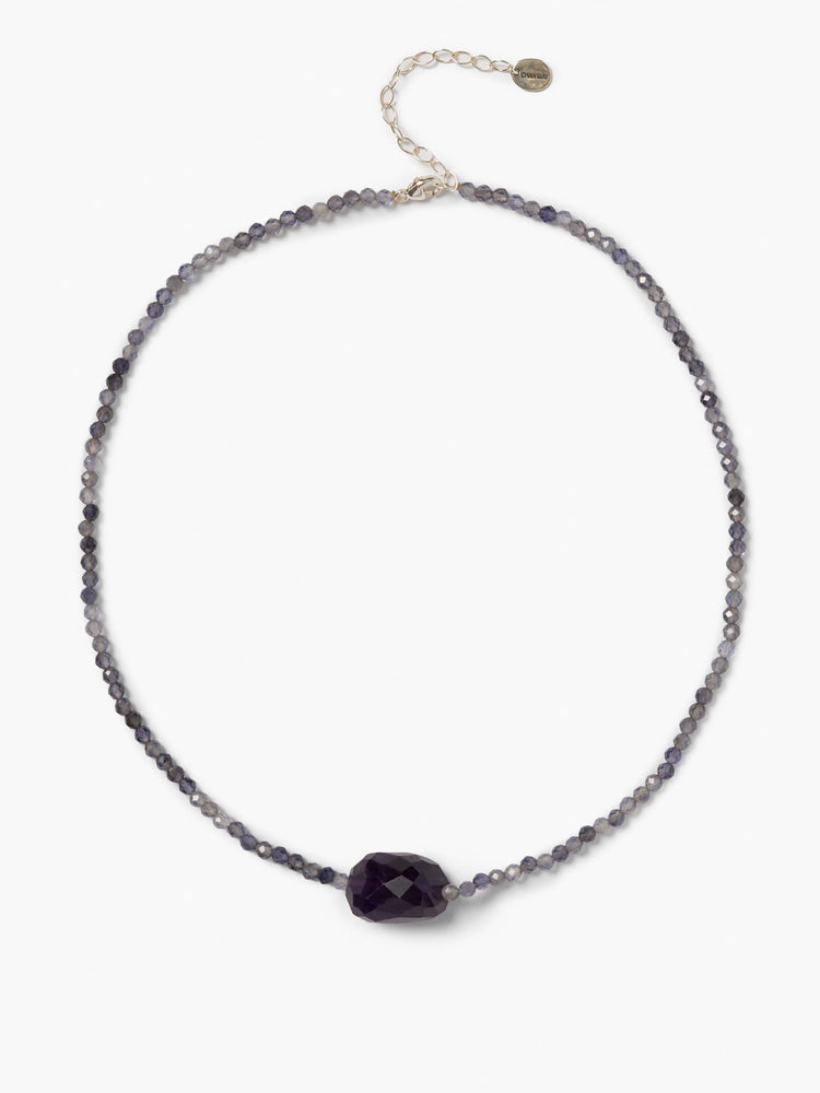 Faceted iolite beaded necklace. Small purplish-blue beads, a large dark purple central bead, and a silver clasp.
