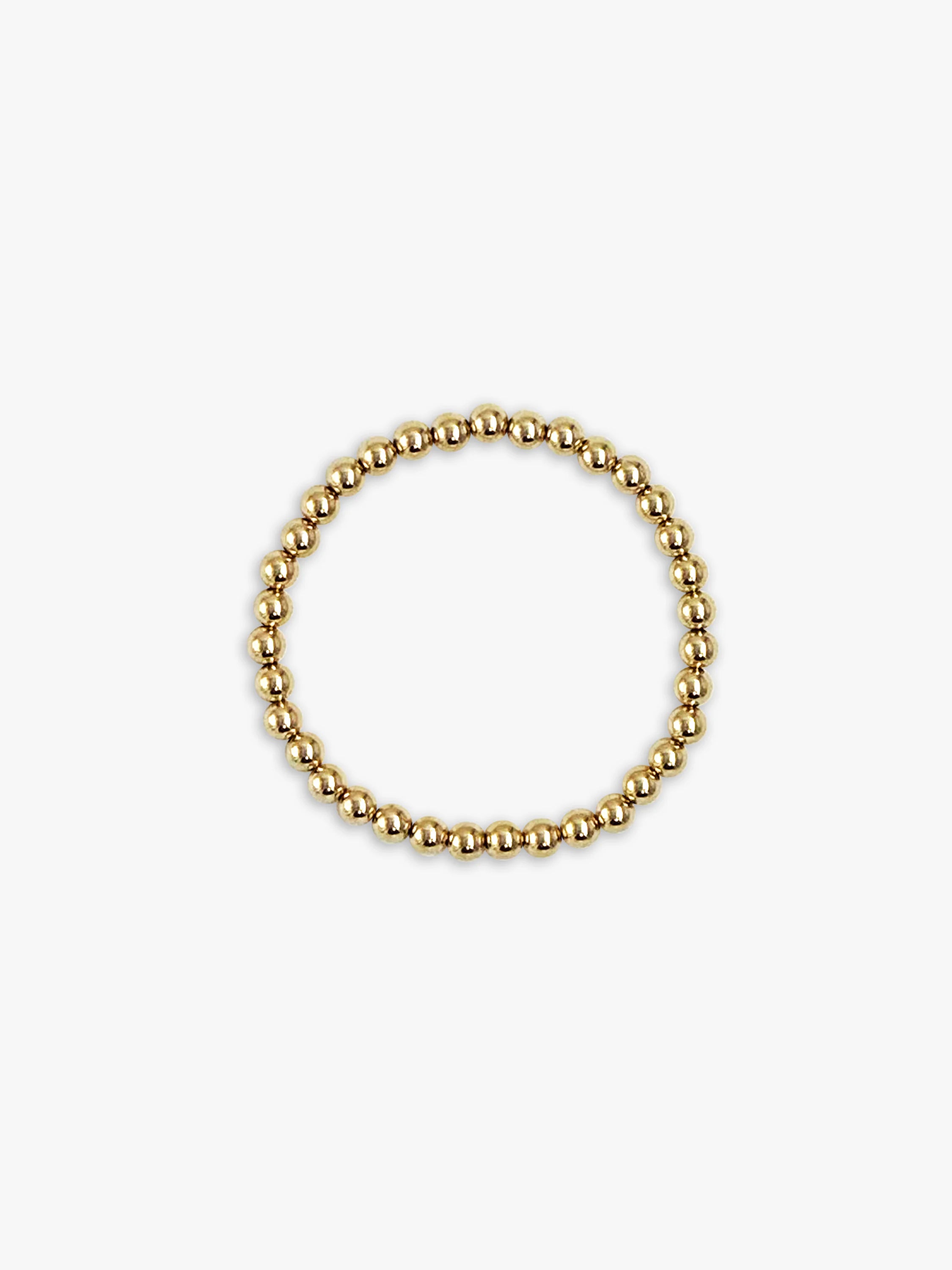 Bracelet of small, shiny gold beads, forming a circle.