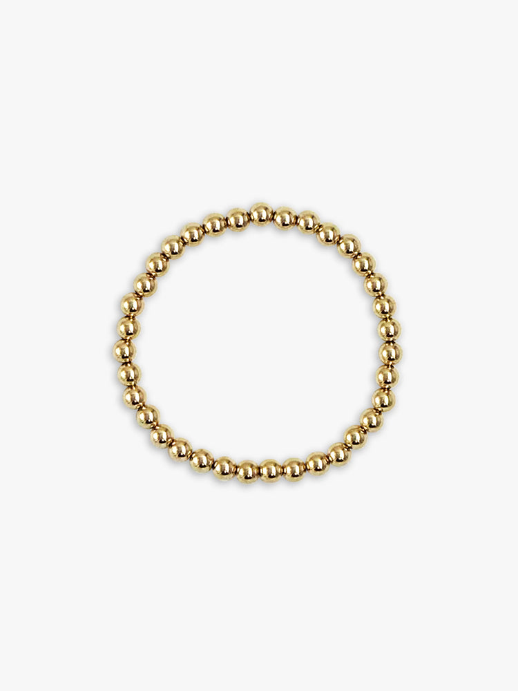 Bracelet of many small, shiny gold spherical beads, forming a continuous circle.