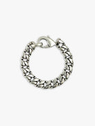 Silver chain bracelet with flat, textured oval links and a lobster clasp, coiled.