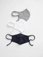 Three fabric face masks: gray, white, and navy, each with adjustable ear loops.