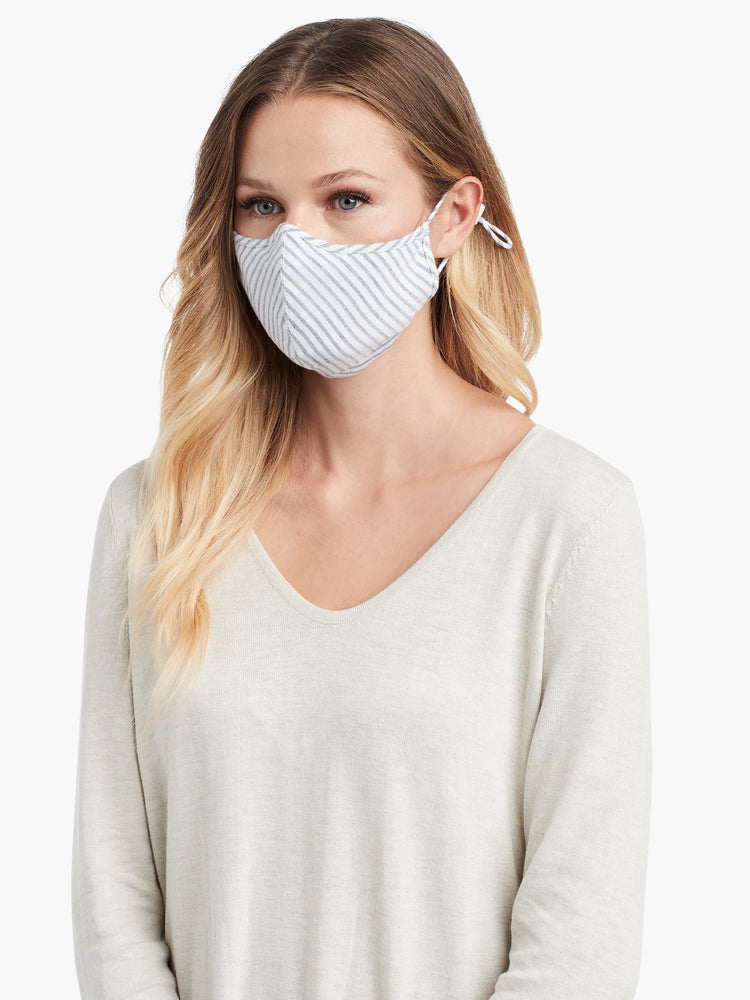 White cloth mask with thin light blue diagonal stripes, covering nose and mouth.