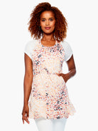 Light bib apron with orange, pink, and black leaf pattern; tie waist & pockets.