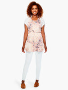 Dorian's Apron: Off-white apron with radiating peach, orange, burgundy, and dark leaf-like pattern; tied at waist.