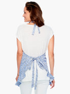 Blue and white patterned apron with ruffled hem and tie closure.  Seen from the back.
