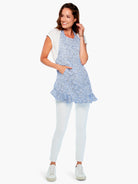 Blue and white patterned apron with ruffled hem and pocket.
