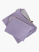Two lavender pouches, one larger, one smaller, with gold zippers. The larger pouch reveals a white lining with a black...