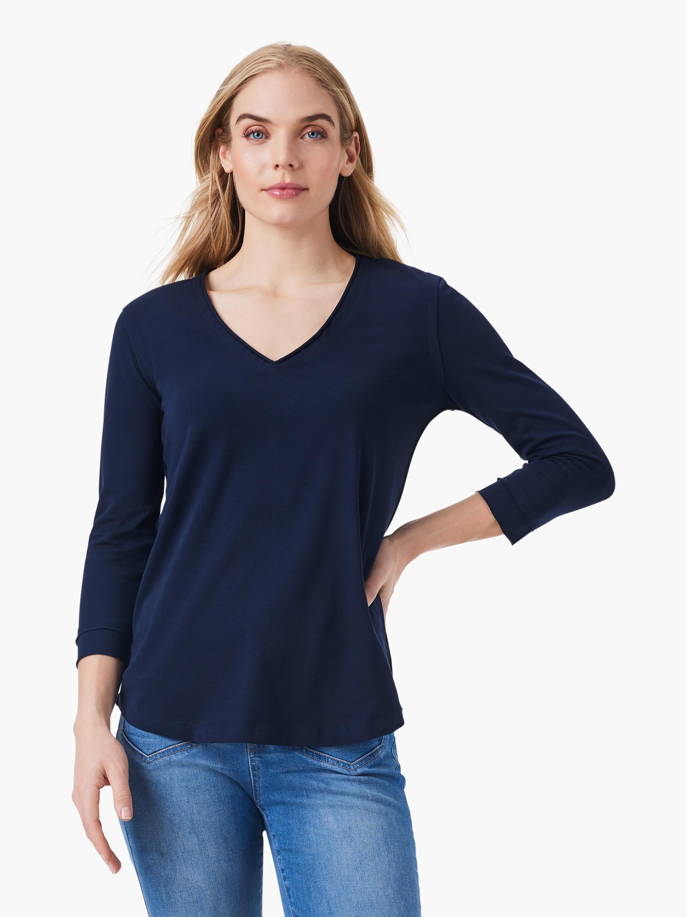 A navy blue v neck top featuring three quarter length sleeves and a relaxed fit paired with blue denim jeans.