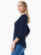 A woman wears a standard-fit navy blue top featuring three-quarter sleeves and a scoop neck.