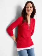 Red long-sleeve top with a V-neck and a hint of white layering.