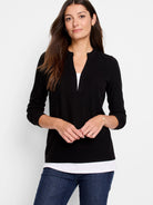 Black long-sleeve top with a small V-neck.  A hint of white underlay is visible at the neckline.