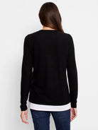 Black long-sleeve top layered over white, shown from the back.