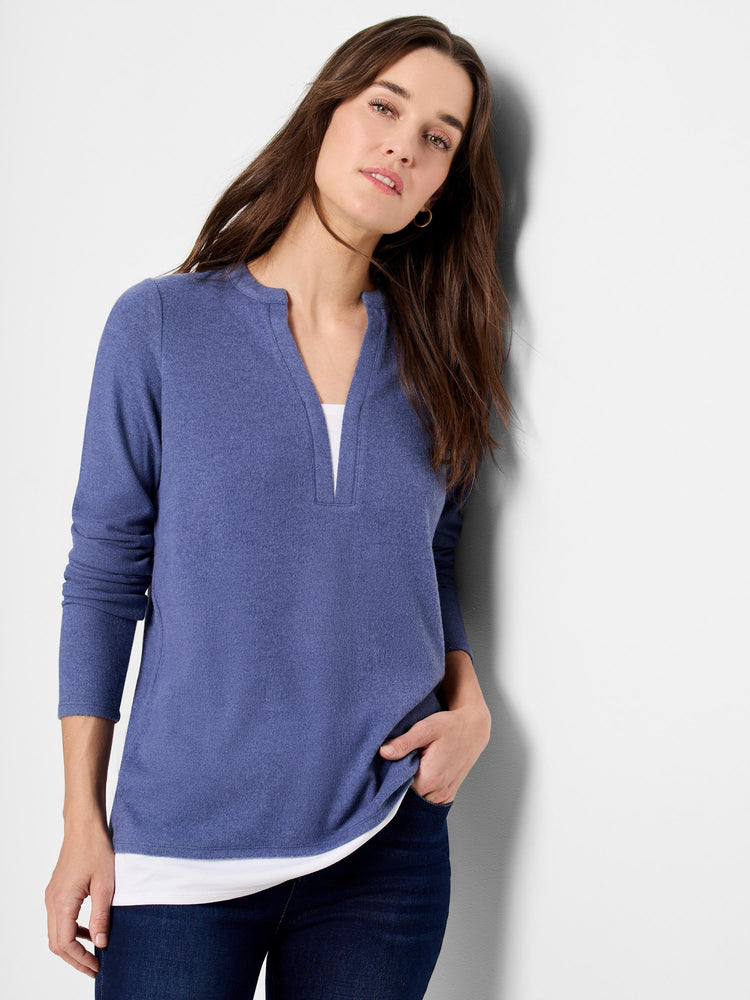 Here's alt text that meets the requirements:

Blue, long-sleeved top with a small V-neck.  Textured fabric.