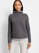 Dark gray mock neck top with lighter gray trim at neck and hem. Long sleeves.