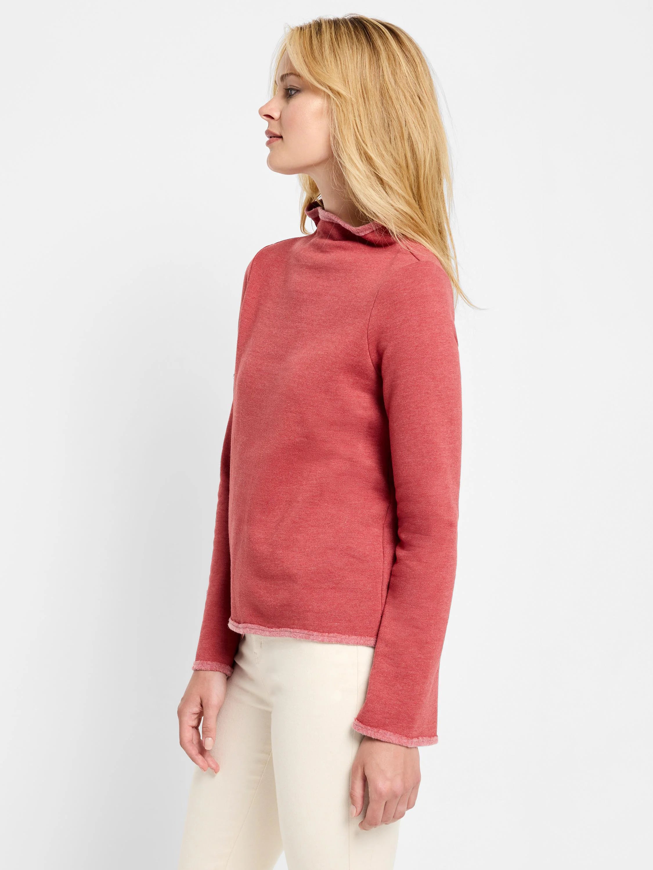 Reddish-pink long-sleeve top with a mock neck and raw edges.