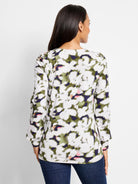 Long-sleeve top, white background with blurred olive green, dark purple, and pink floral print.  Long sleeves.