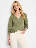 Olive green long-sleeve v-neck top with lace detailing at shoulder.