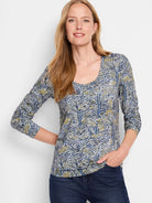 Long-sleeve scoop neck shirt;  off-white background with blue, green, and beige sketched lines forming an abstract pattern.