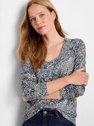 Long-sleeve scoop neck shirt; off-white background with teal, olive green, and dark blue sketched lines pattern.