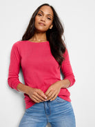Pink, three-quarter sleeve boatneck shirt.  Textured fabric. Model wears light wash jeans.