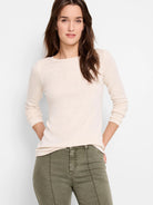 Off-white long-sleeve shirt, crew neck,  worn with olive green pants.