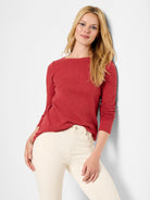 Red long-sleeve boat neck shirt; textured fabric.