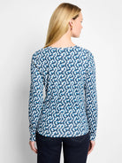 Back view of a white long sleeve boat neck tee with an abstract geometric print in shades of blue.