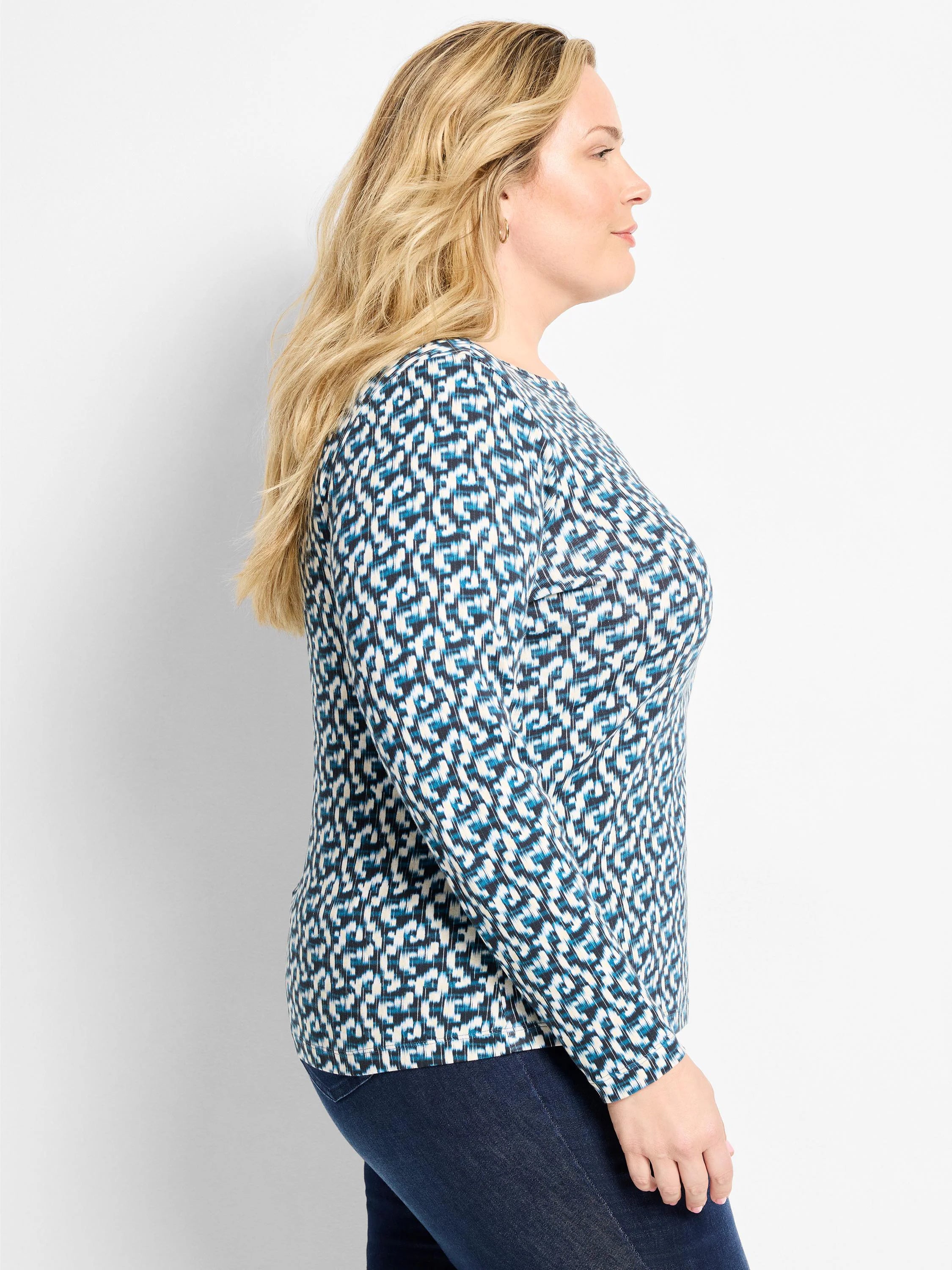 Teal, black, and cream geometric print long sleeve boat tee worn by a woman in profile.