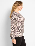Light tan long sleeve boat neck tee with a dark, stylized linear print.