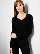 Black, long-sleeved V-neck knit shirt.  Textured fabric.