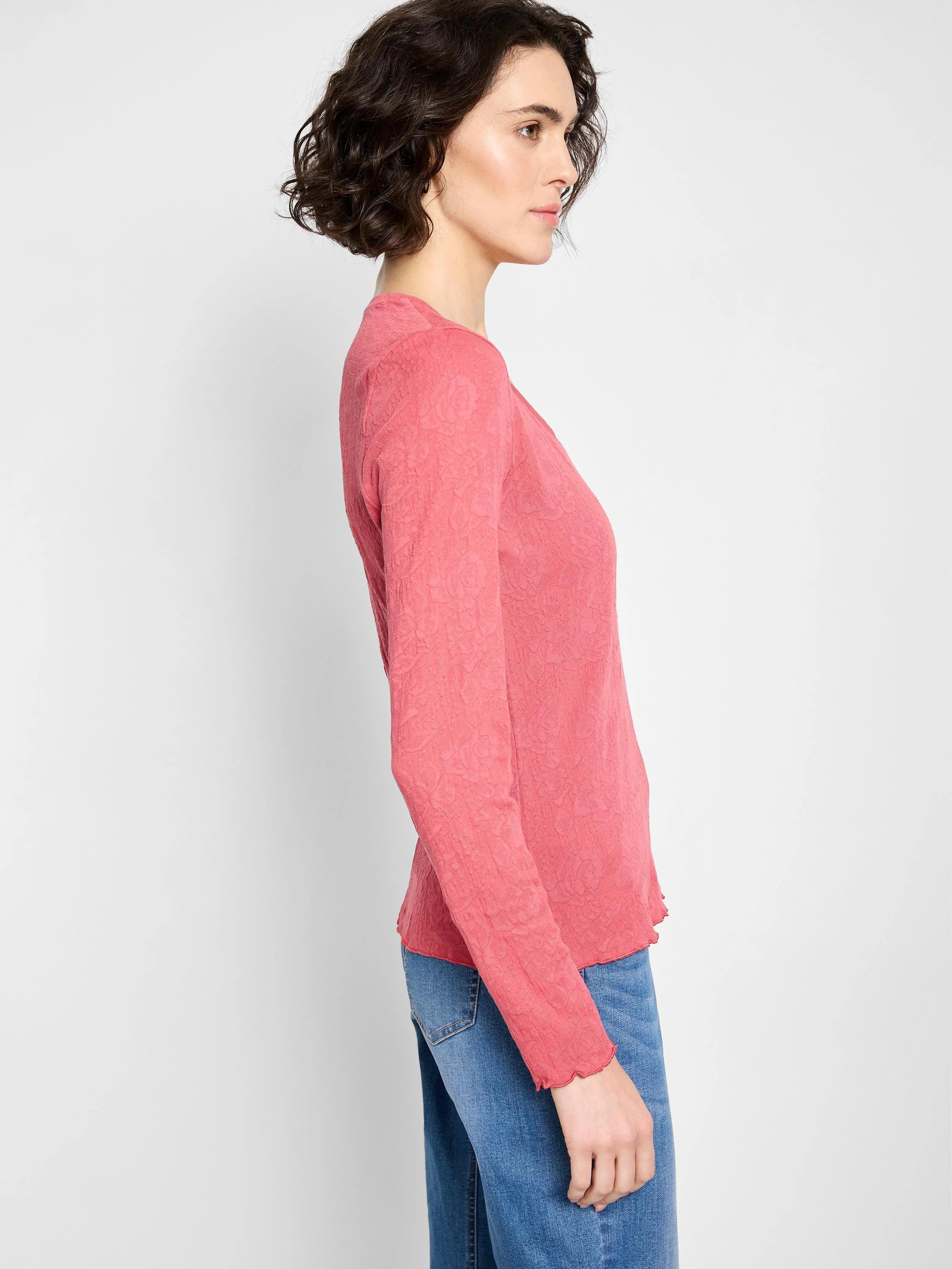 Coral pink, long-sleeved V-neck shirt.  Textured knit fabric with scalloped hem.