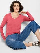 Coral pink, textured V-neck, long sleeves with ruffled cuffs.  Long-sleeved shirt.