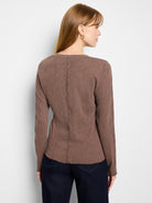 Brown long-sleeve V-neck shirt; textured knit fabric with subtle pattern; raw-edge hem and cuffs.
