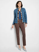 Blue V-neck knit top with darker blue and brown patterned detailing.  Brown pants and light blue shoes are also shown.