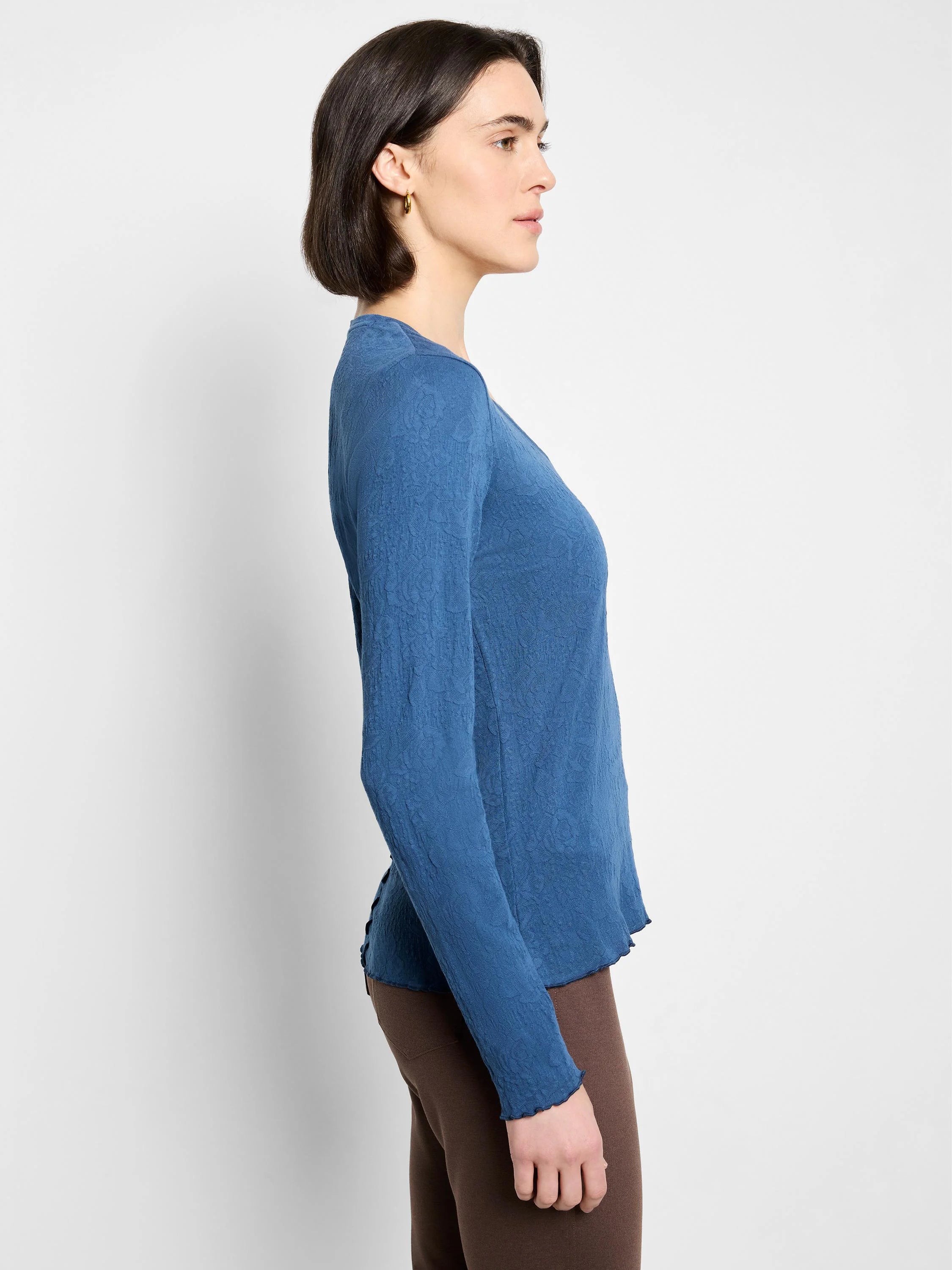 Blue, long-sleeved V-neck knit shirt with textured fabric.  Slightly scalloped hem.