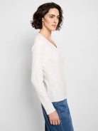 Off-white, long-sleeve V-neck knit shirt with textured fabric.