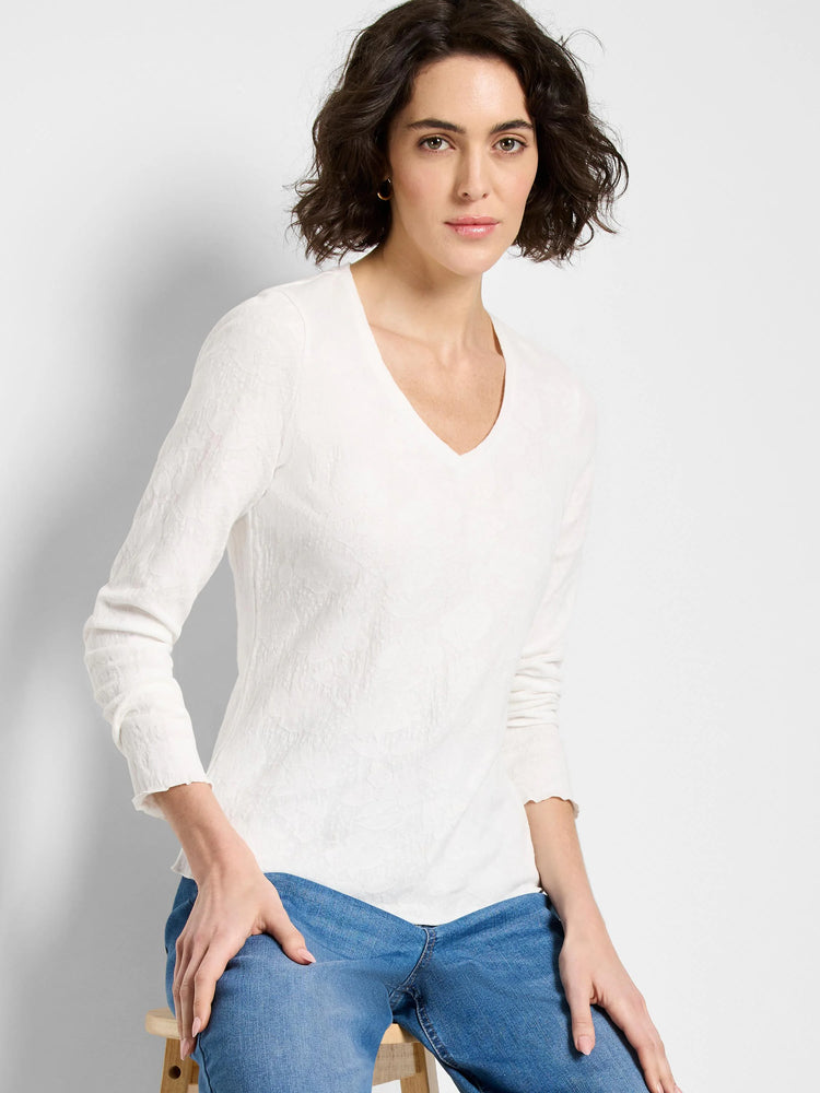 Off-white, long-sleeve V-neck knit shirt with textured surface.