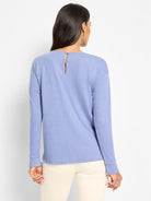 Periwinkle blue long-sleeved knit top, seen from behind, features a back button closure with a keyhole detail.