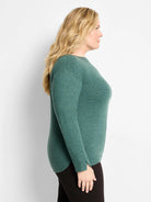 Heathered teal green long-sleeve top with boat neck, curved hem, and thumbhole cuffs.