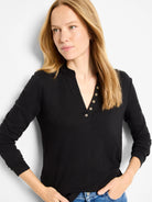 Black long-sleeve henley shirt with  gold buttons and a subtle textured fabric.