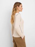 Pale beige long sleeve tee with dark piping on shoulder and side seams.