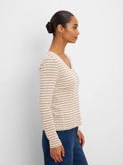 Cream long sleeve tee with thin tan horizontal stripes and a V-neck.