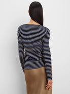 Navy blue and cream horizontal striped long sleeve tee, shown from the back on a model.