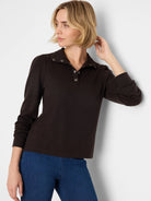 Dark brown collared tee with silver snap buttons, subtle puff sleeves.