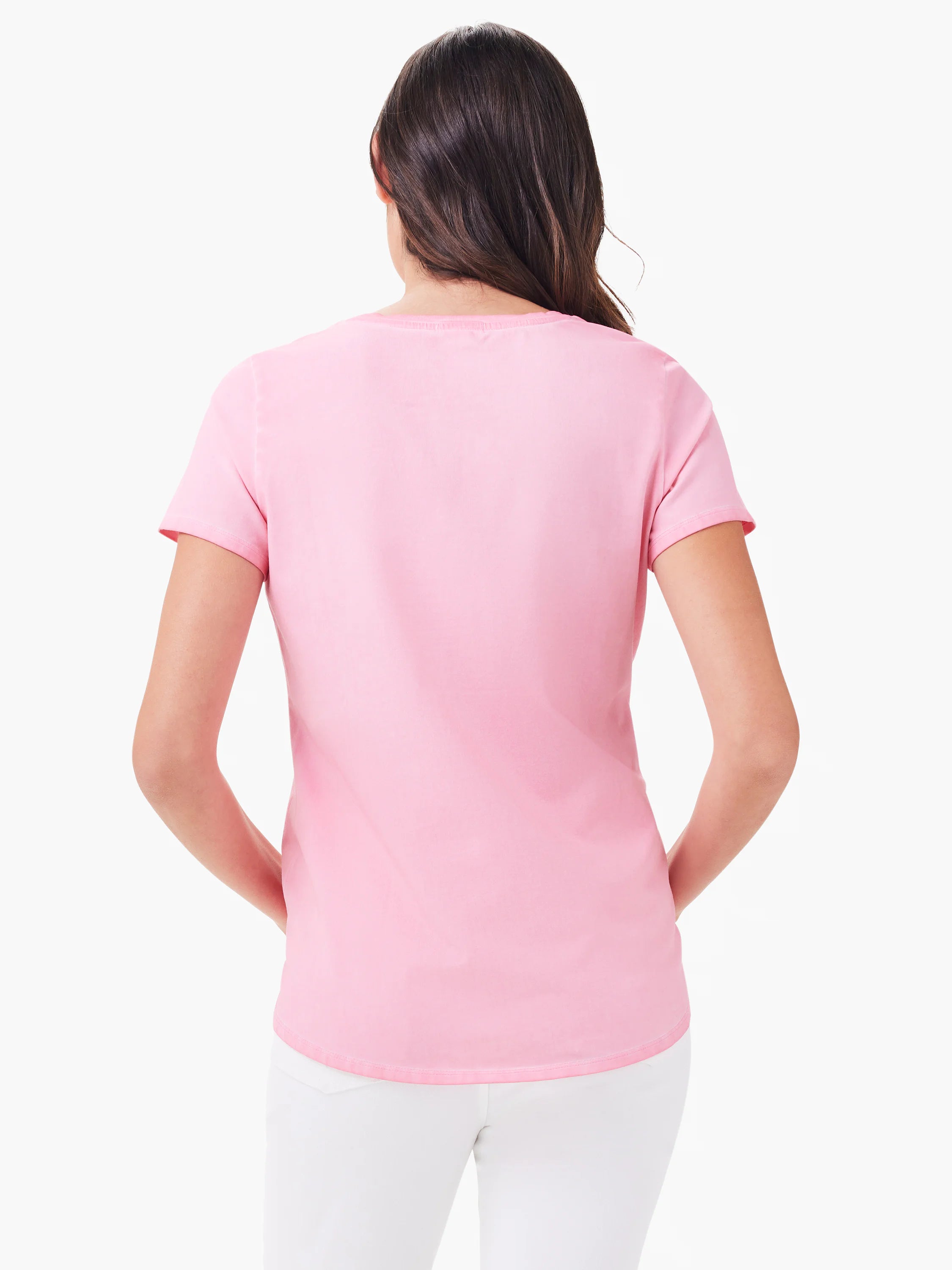 Back view: pink short sleeve shirt tail crew neck tee on a model, worn with white pants.
