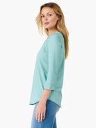 Light teal 3/4 sleeve V-neck tee with roll cuffs and a washed fabric texture.