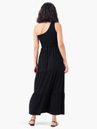 Black tiered maxi dress, one-shoulder neckline, smocked bodice.  Back view.